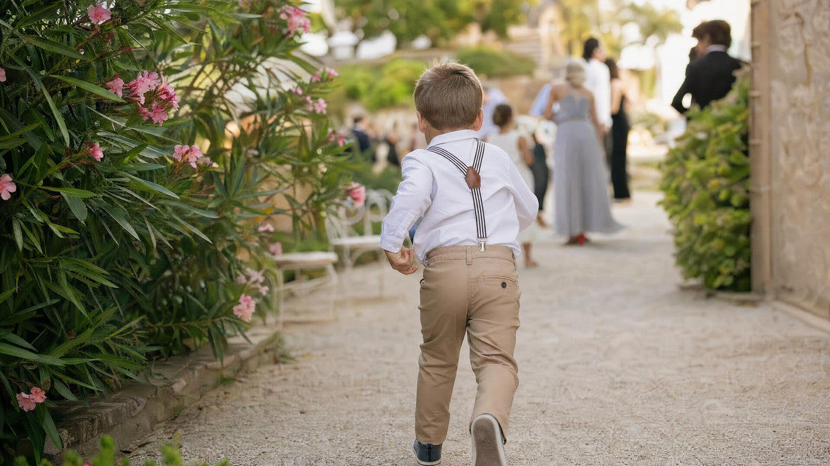 Enfant portant des bretelles pour une cérémonie, tenue élégante et naturelle.